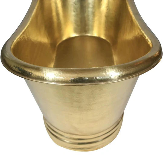 Handcrafted solid brass bathtub with natural patina finish beside window light
