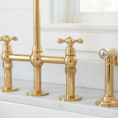 Gold faucet set on a marble countertop with a white wall background